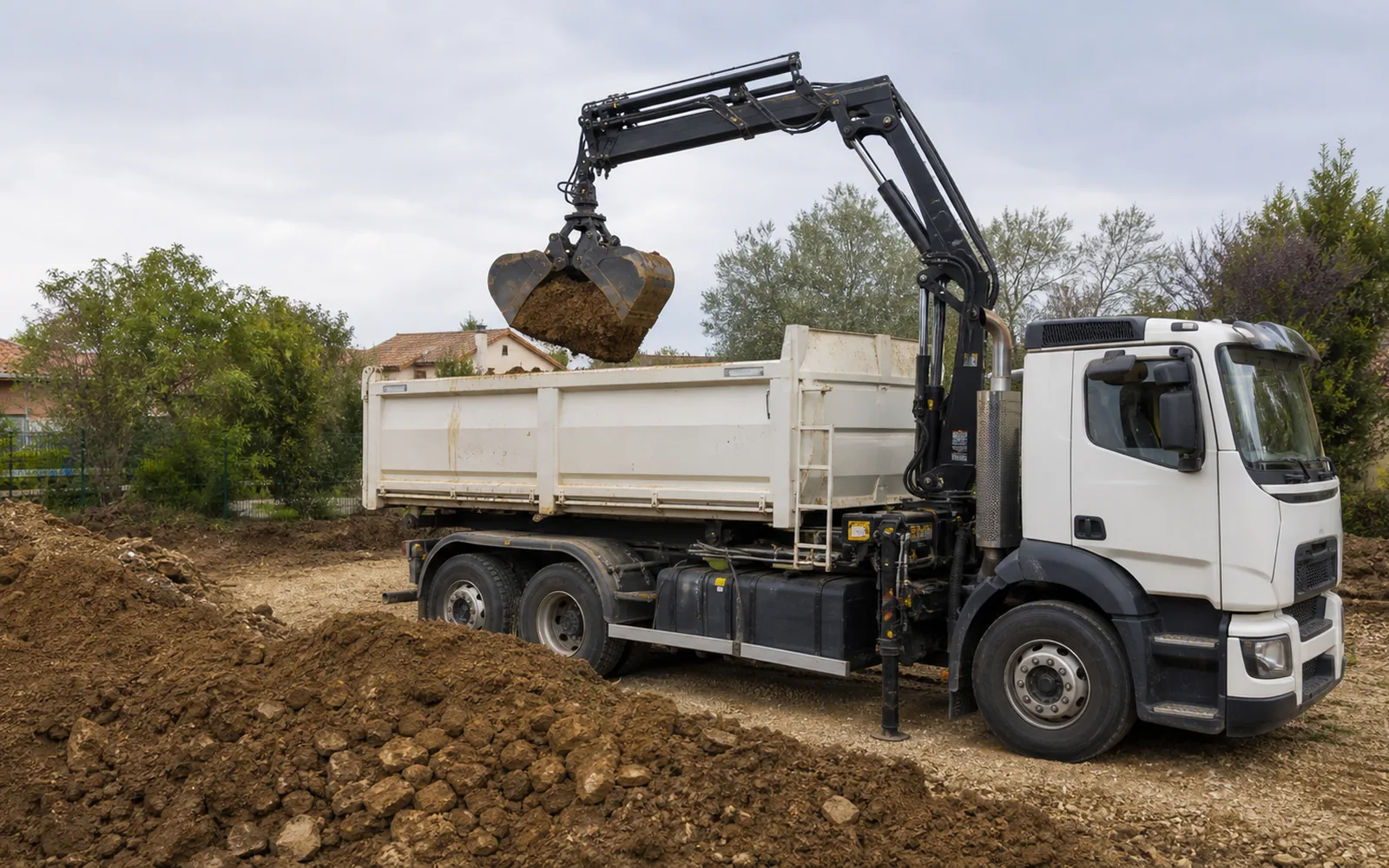 Camion-grue évacuant de la terre et du déblai après terrassement à Montauban
